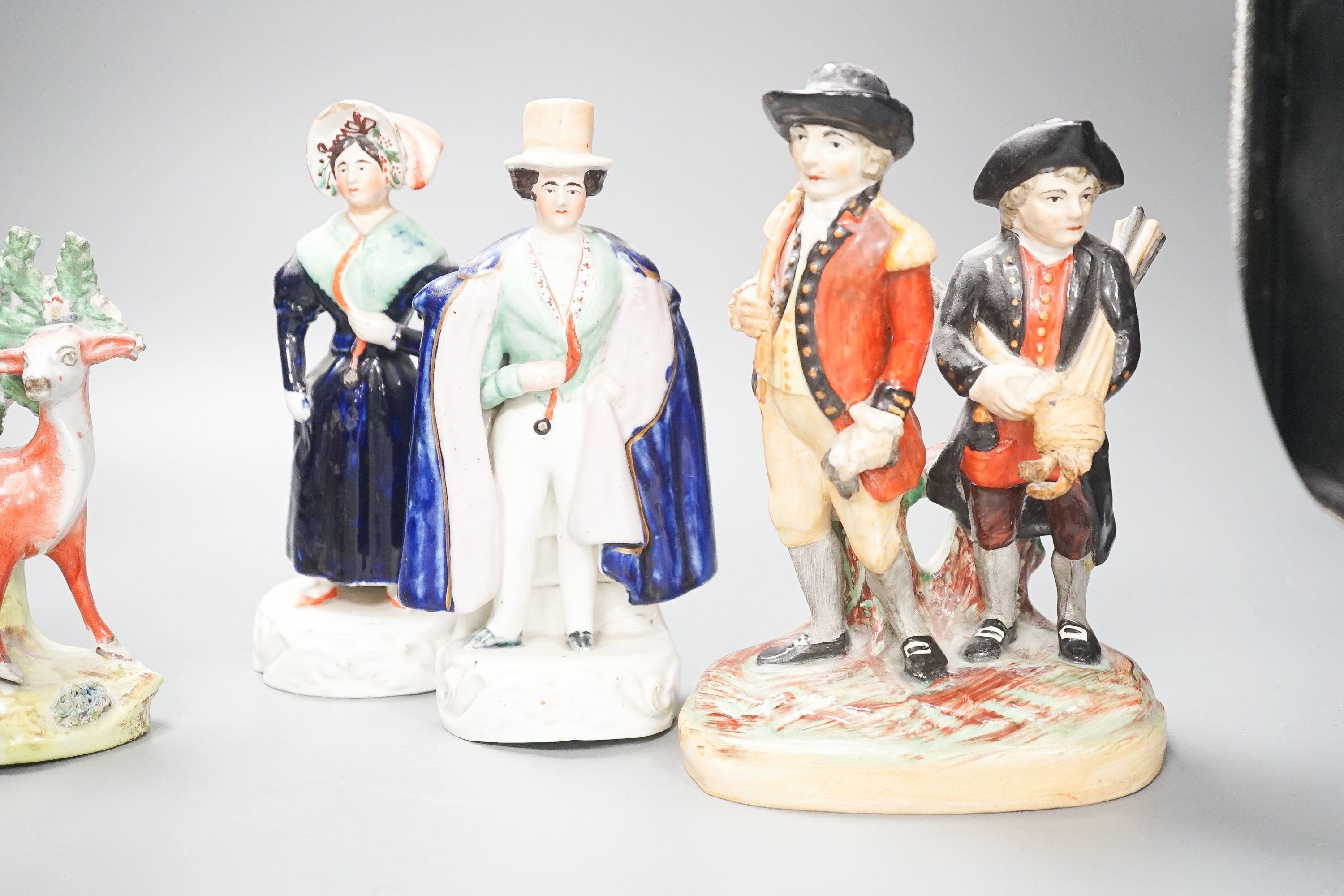 A group of Staffordshire figures, including a pair of deer standing before bocage, 15cm, a Victorian couple, 19 cm and a golfing group, 20 cm (6)